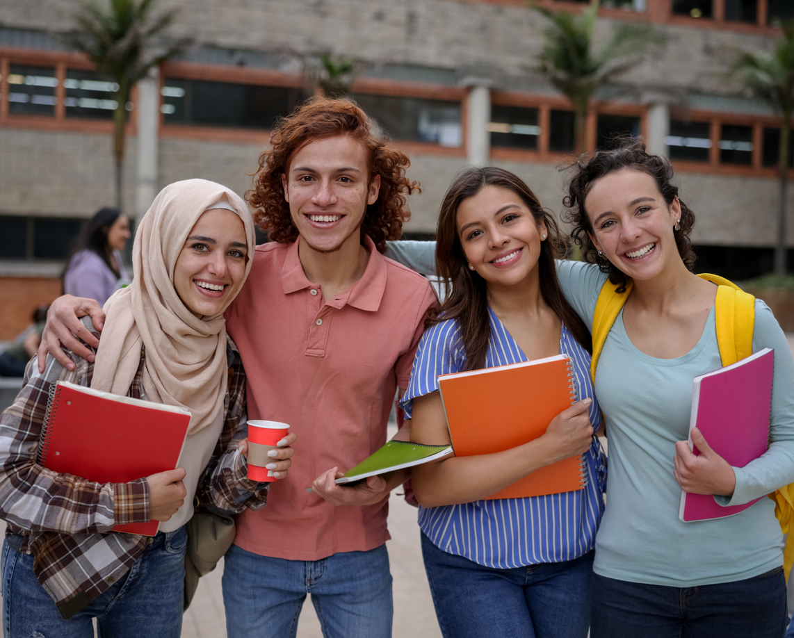 Happy multi-ethnic group of Latin American college students smiling at the university campus and looking at the camera - education concepts