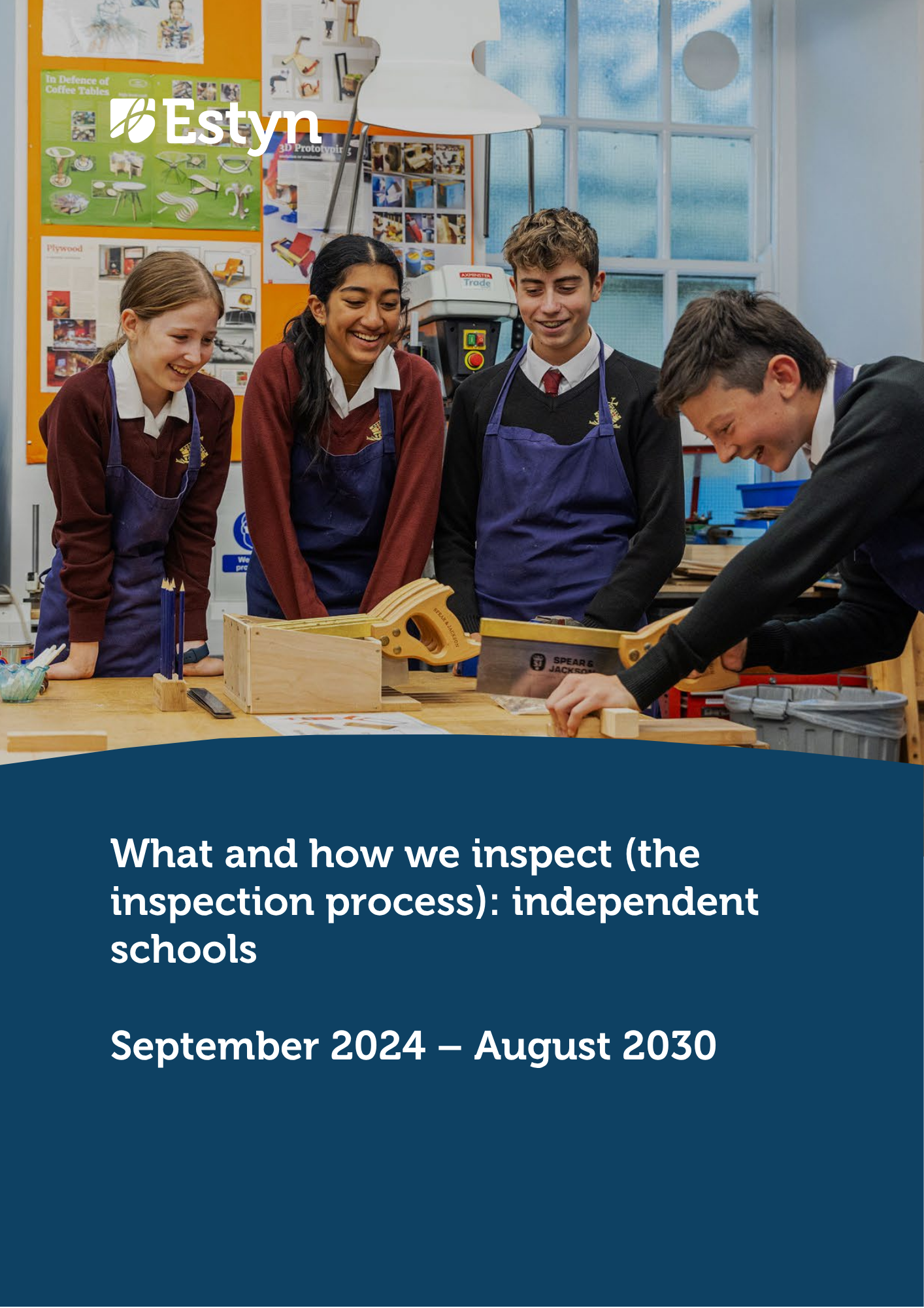 A group of secondary school pupils wearing protective aprons taking part in a practical design and technology lesson, gathered around a project in a workshop classroom.
