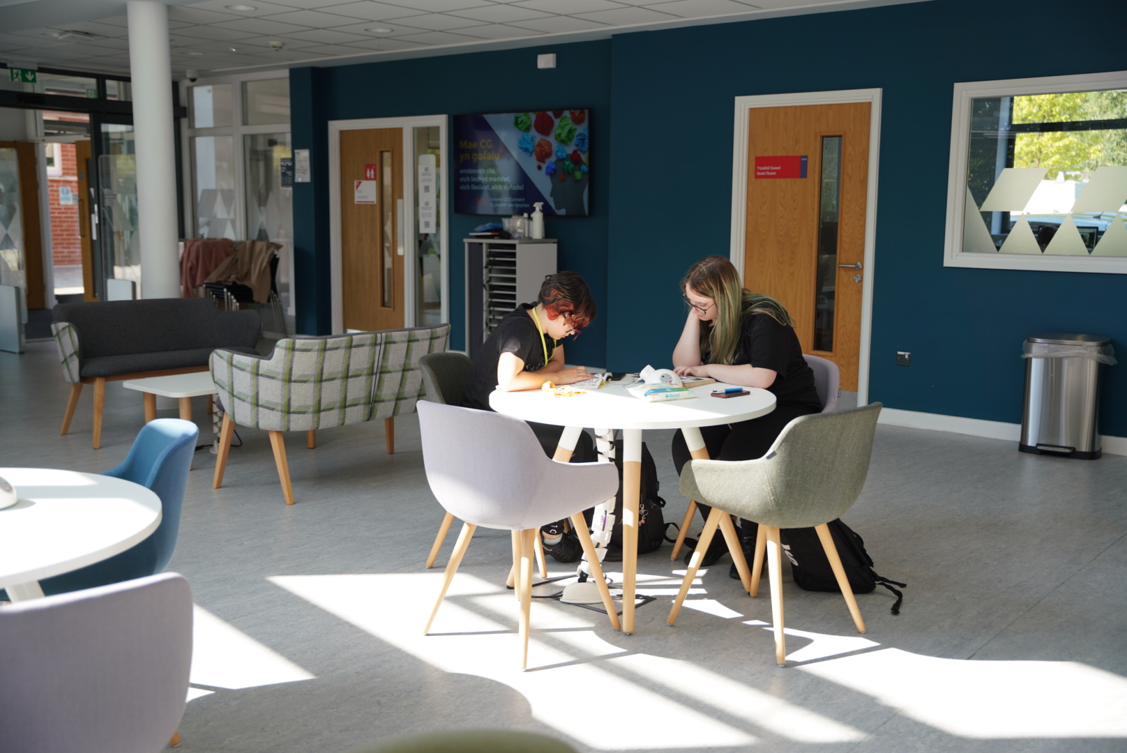 Two learners sat working at a round table of a college in Wales