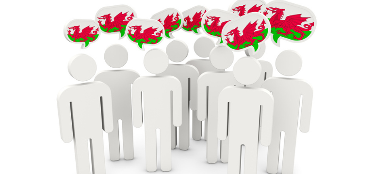 Group of generic figures with speech bubbles displaying the flag of Wales above their heads.