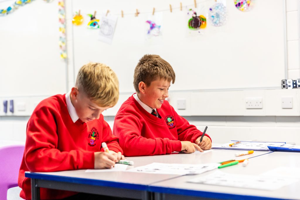 Two pupils colouring in in school