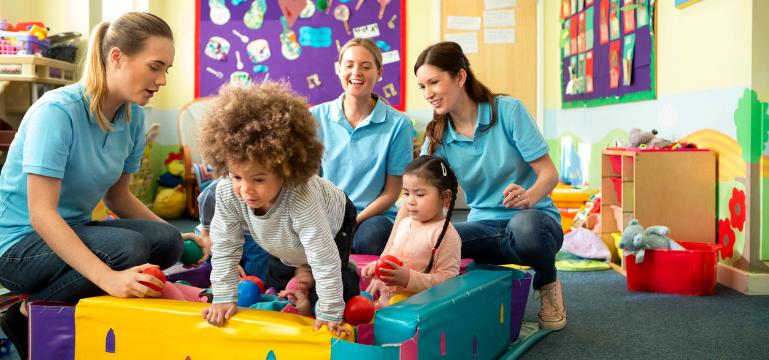 Adults supervising children playing with toys in a vibrant preschool classroom.