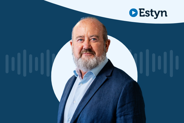 A portrait of a professional individual with the Estyn logo on the upper right, set against a dual-tone background of dark blue and white.