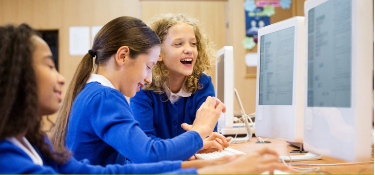 Students using desktop computers together during a classroom ICT lesson.