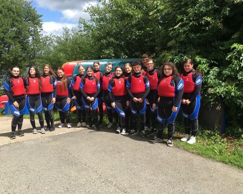 Young people wearing wetsuits and lifejackets